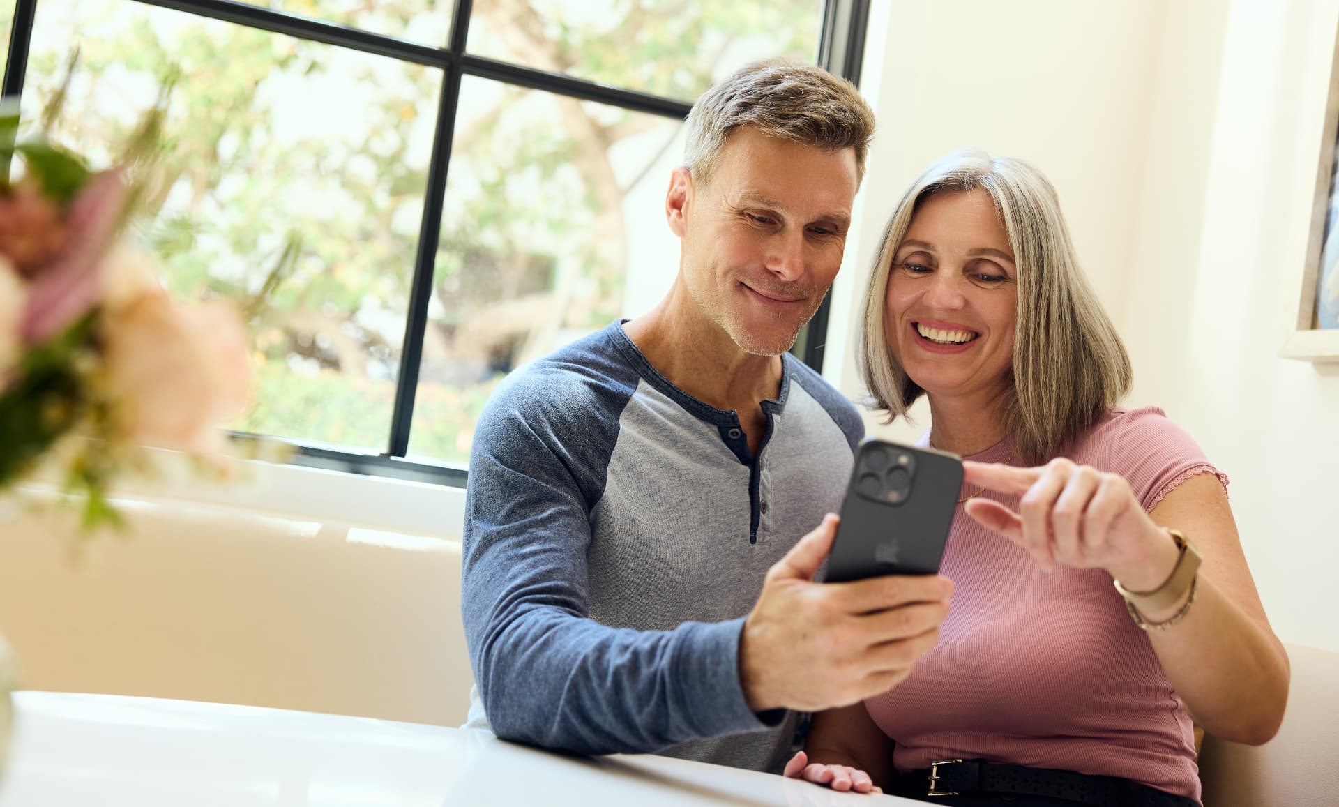 Couple in their 50s looking at a phone together without reading glasses